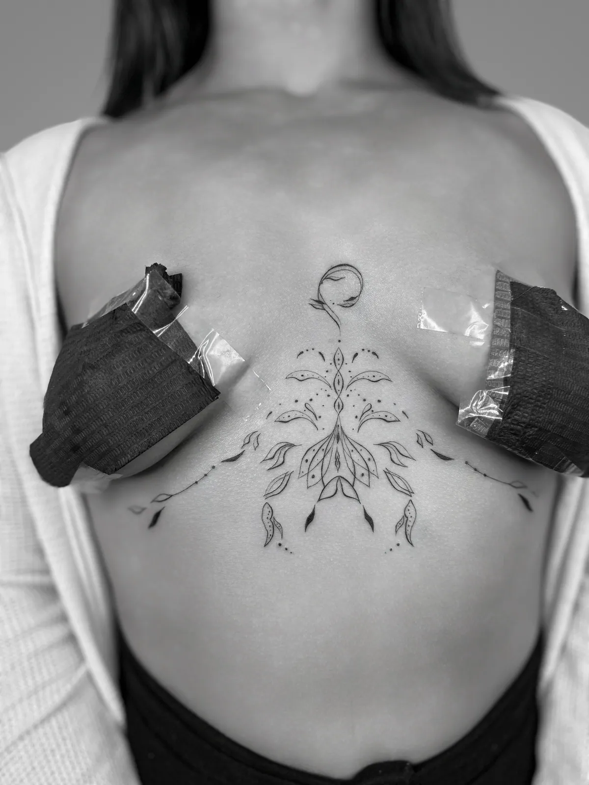 Ornamental tattoo across the sternum
